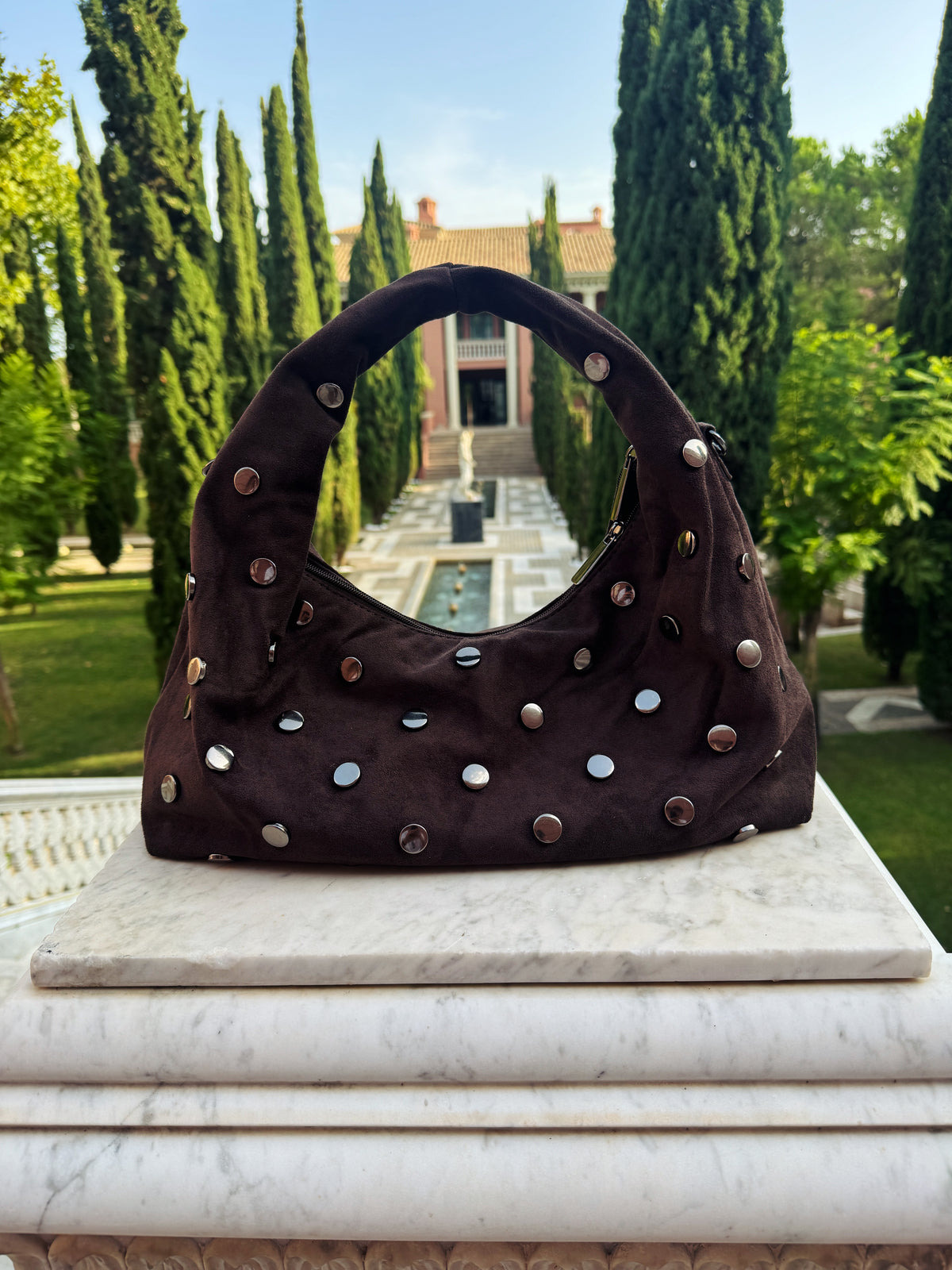 Chocolate Élise Bag – dameshandtas met zilveren studs van Gabianna Fashion, gefotografeerd in een elegante tuinomgeving