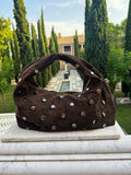 Khaki Élise Bag – dameshandtas met zilveren studs van Gabianna Fashion, gefotografeerd in een elegante tuinomgeving